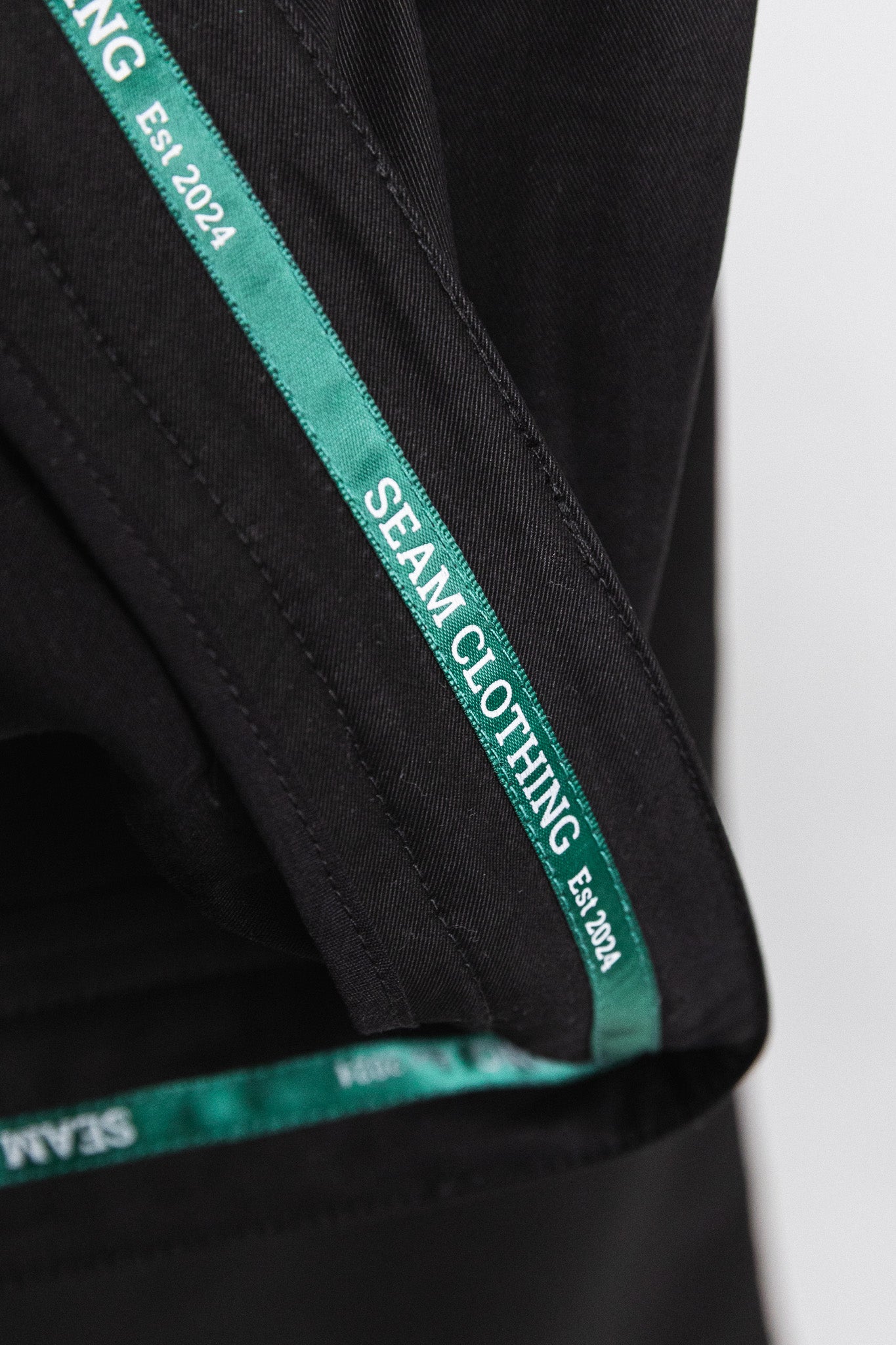SEAM Poplin Pleated Trouser in Black, interior label showing Seam Clothing branding