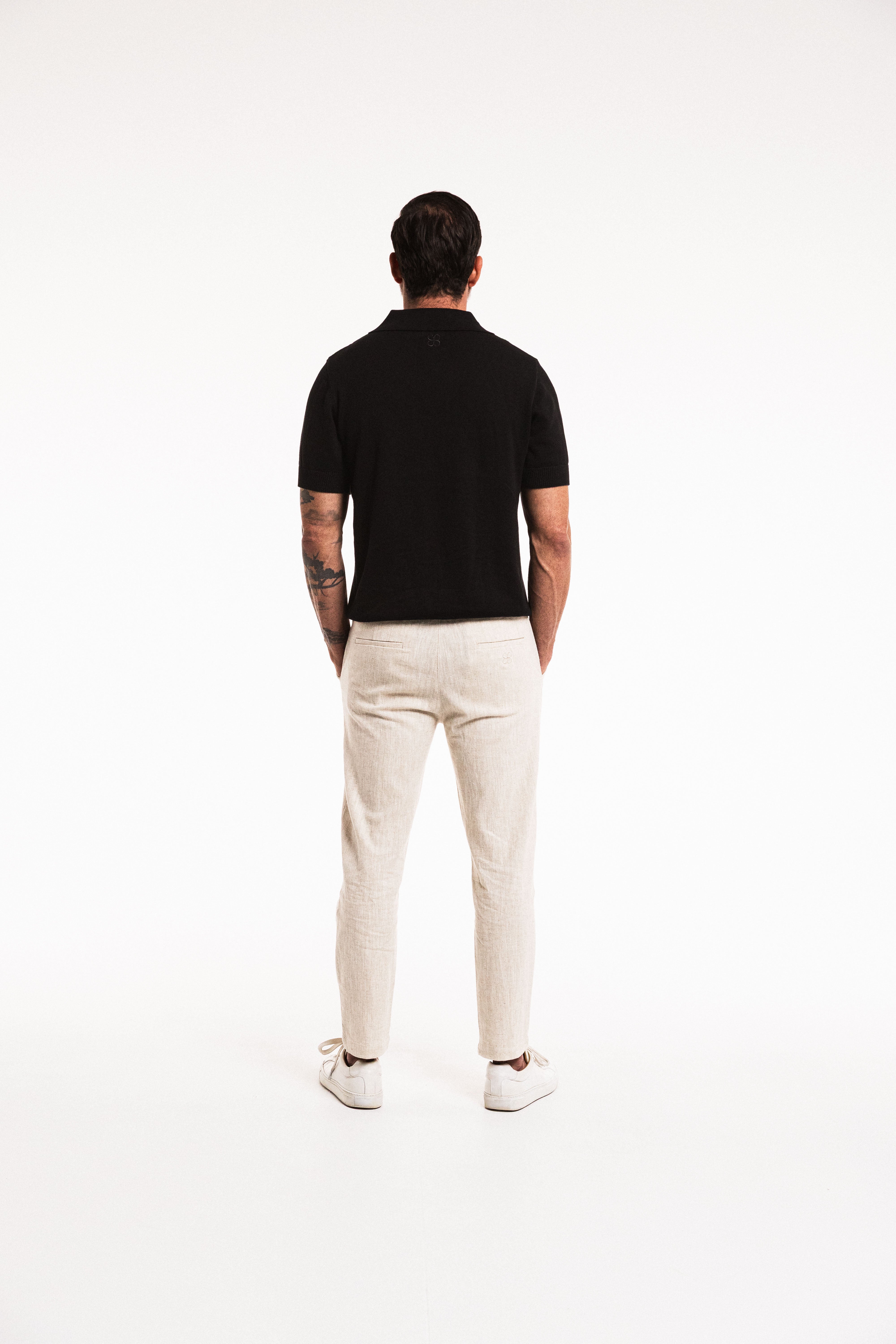 Back view of model wearing Classic Polo in Obsidian – ribbed collar and knit detail