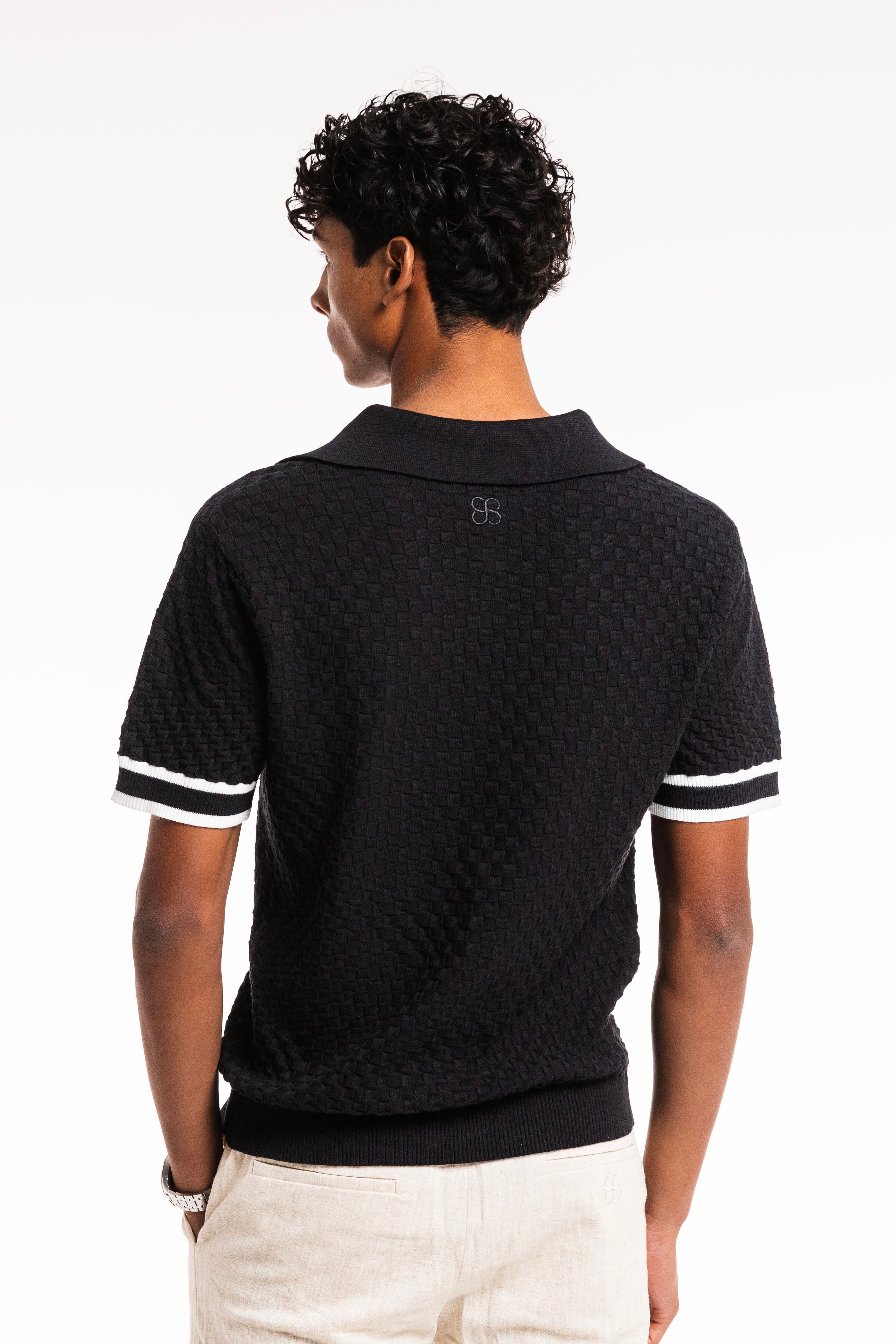 Checkered Cotton Knit Polo in Obsidian featuring a sleek collar and contrast sleeve stripes.