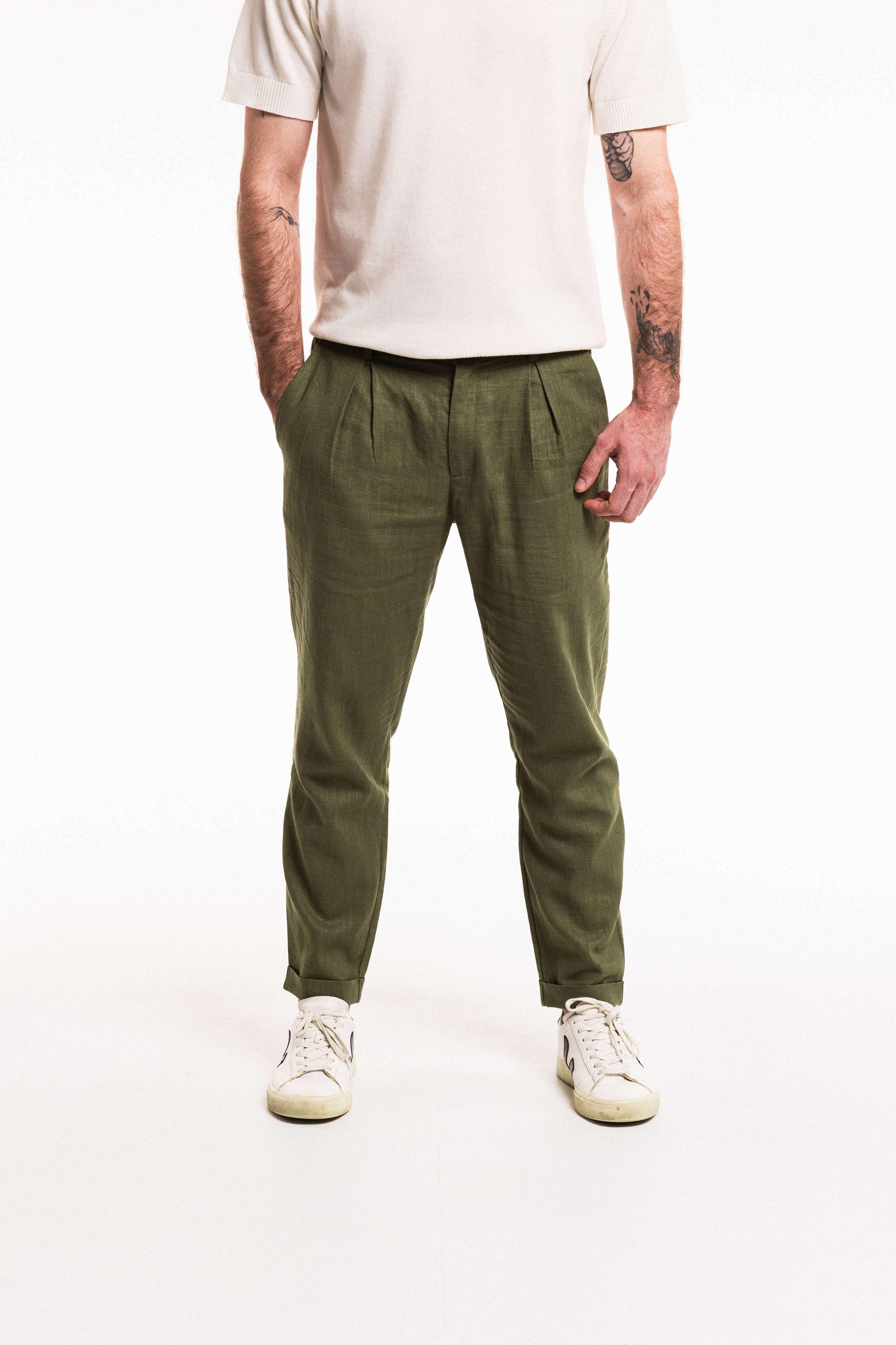 Person wearing olive green pants and a white shirt on a white background