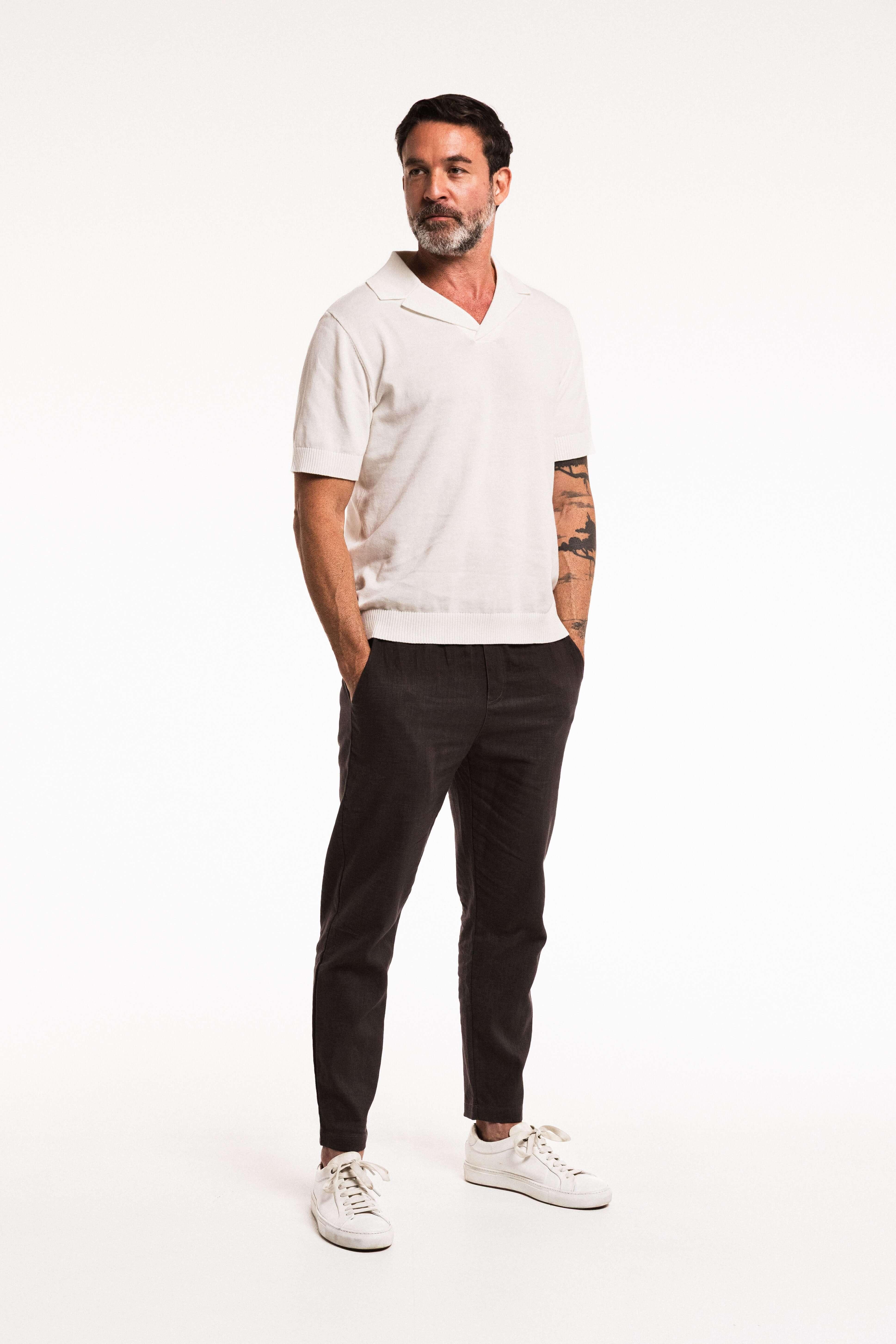 Man wearing Tailored Lounge Linen Pant in Charcoal with a light polo shirt and sneakers.