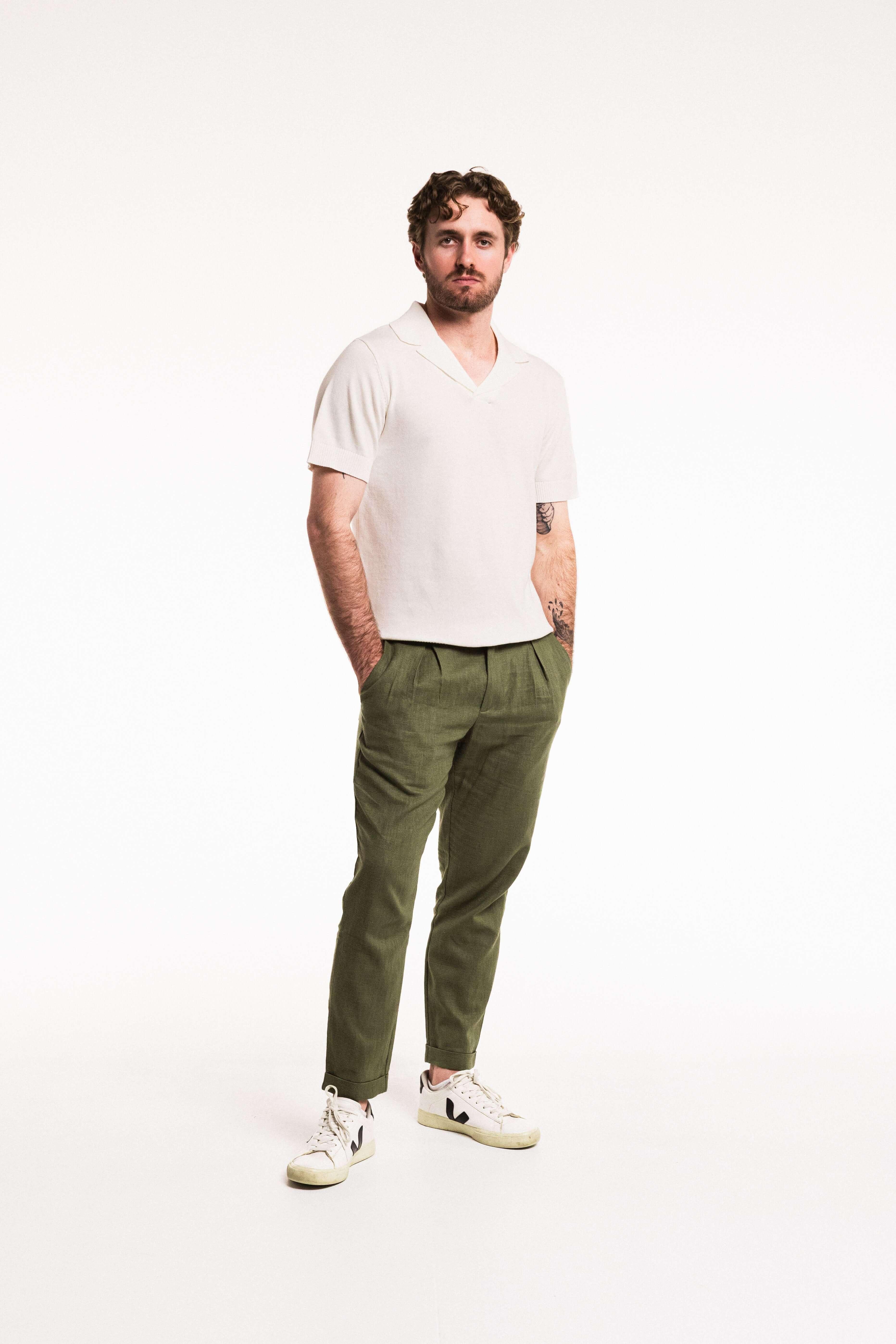 Man wearing Pleat Cuff Linen Trouser in Olive, showcasing tailored style and relaxed fit.