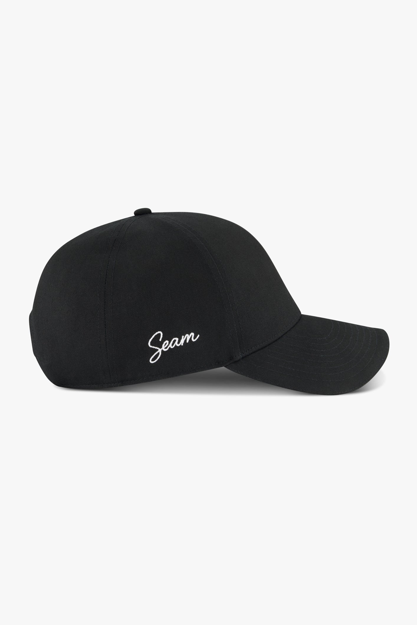 SEAM Cotton Logo Cap in Black, side profile showing structured six-panel design