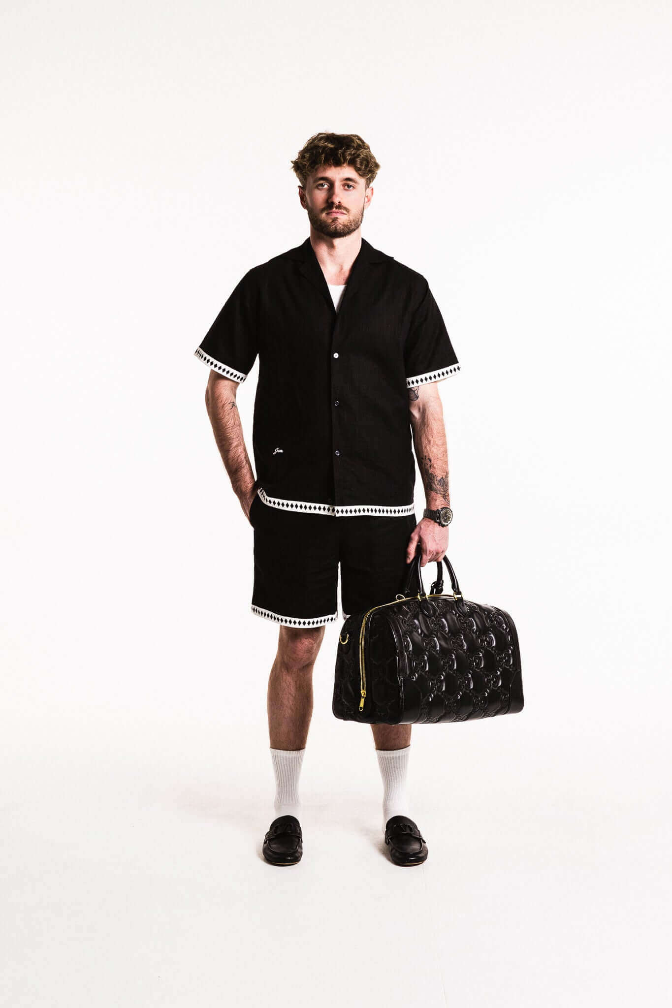 Model wearing Diamond Trim Linen Shirt with shorts and carrying a designer bag, showcasing relaxed style and versatility.