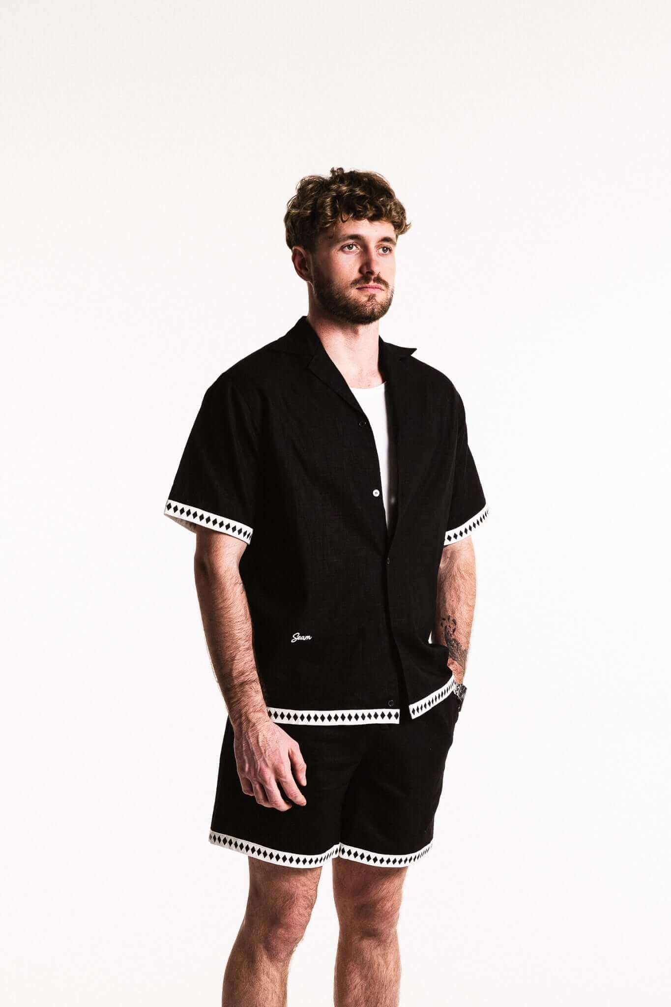 Man wearing Diamond Trim Linen Shirt in black with white contrast trim, showcasing relaxed and sophisticated style.