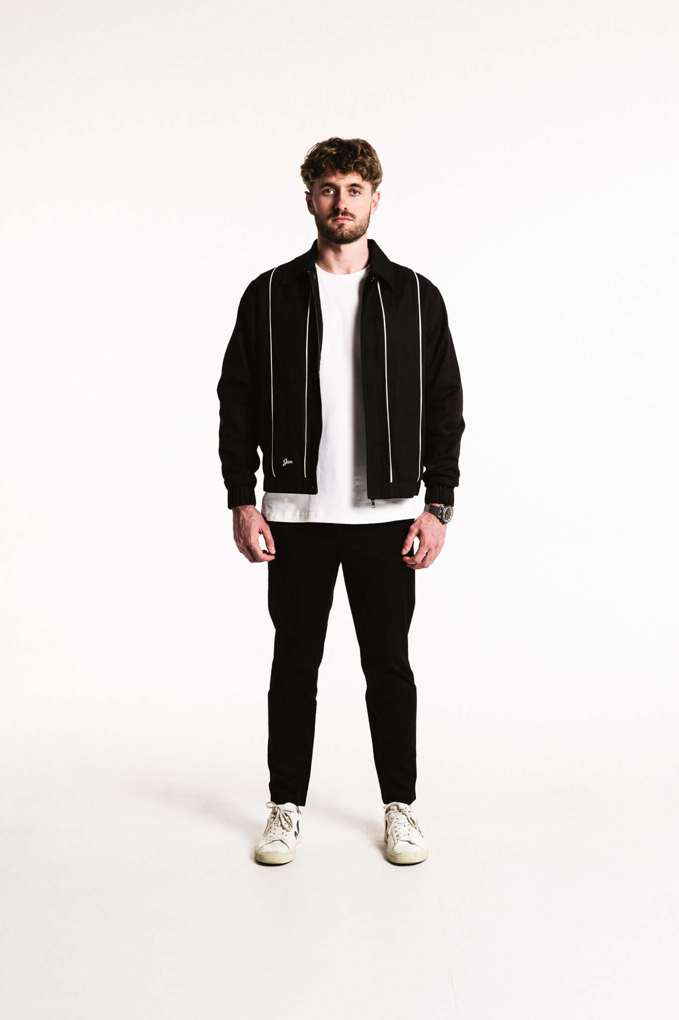 Cotton Contrast Jacket in Black with white piping, styled with a t-shirt and black pants, featuring modern design.