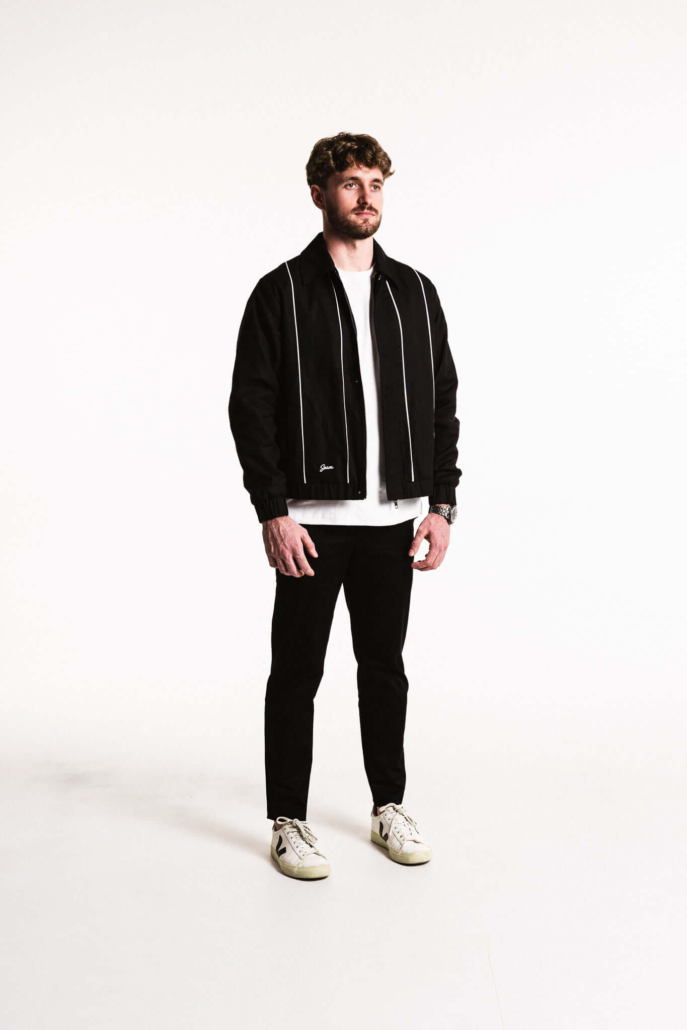 Model wearing a Cotton Contrast Jacket in Black with white piping, paired with a casual outfit.