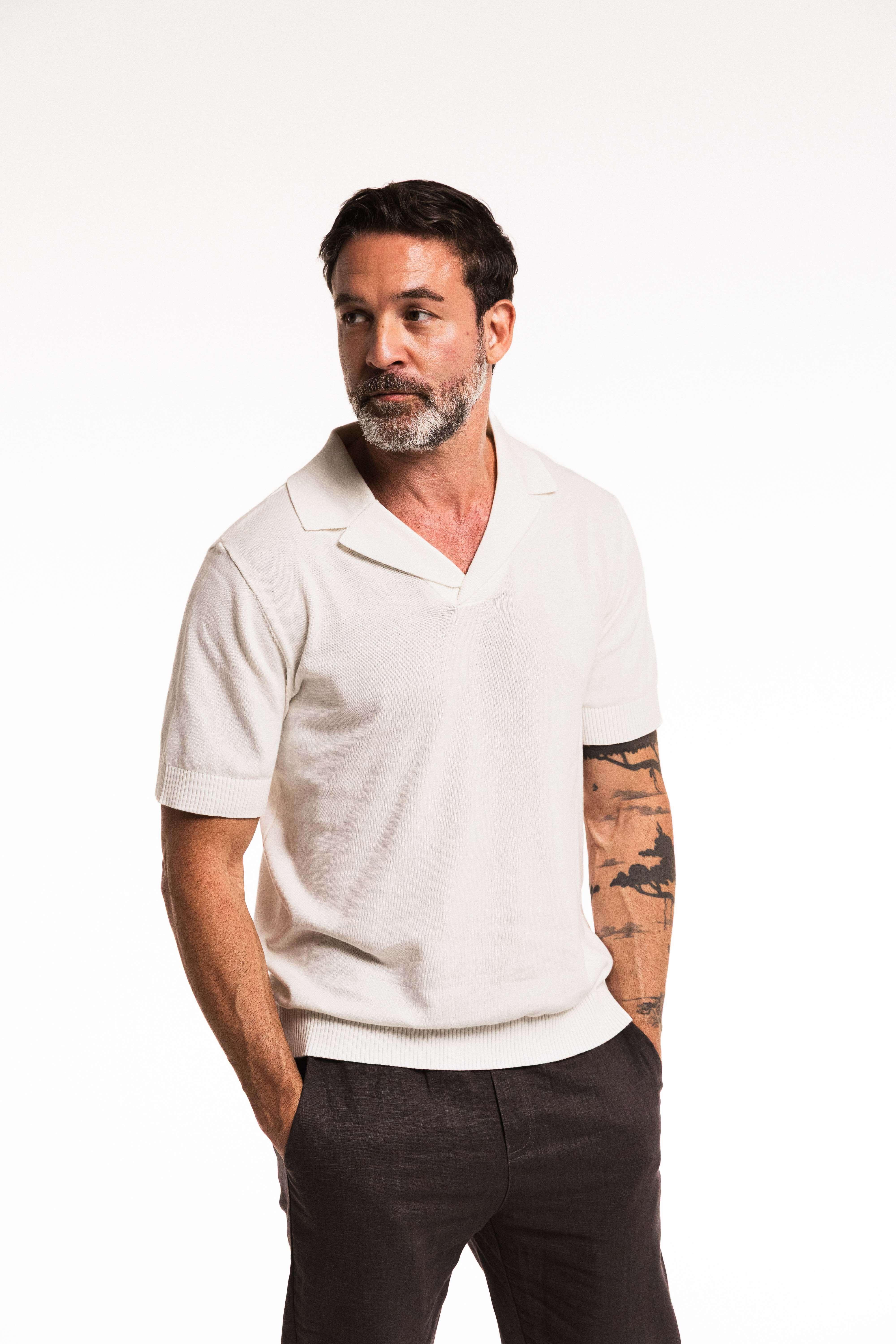 Man wearing a Classic Cotton Knit Polo in white, featuring a relaxed fit and elegant polo collar.