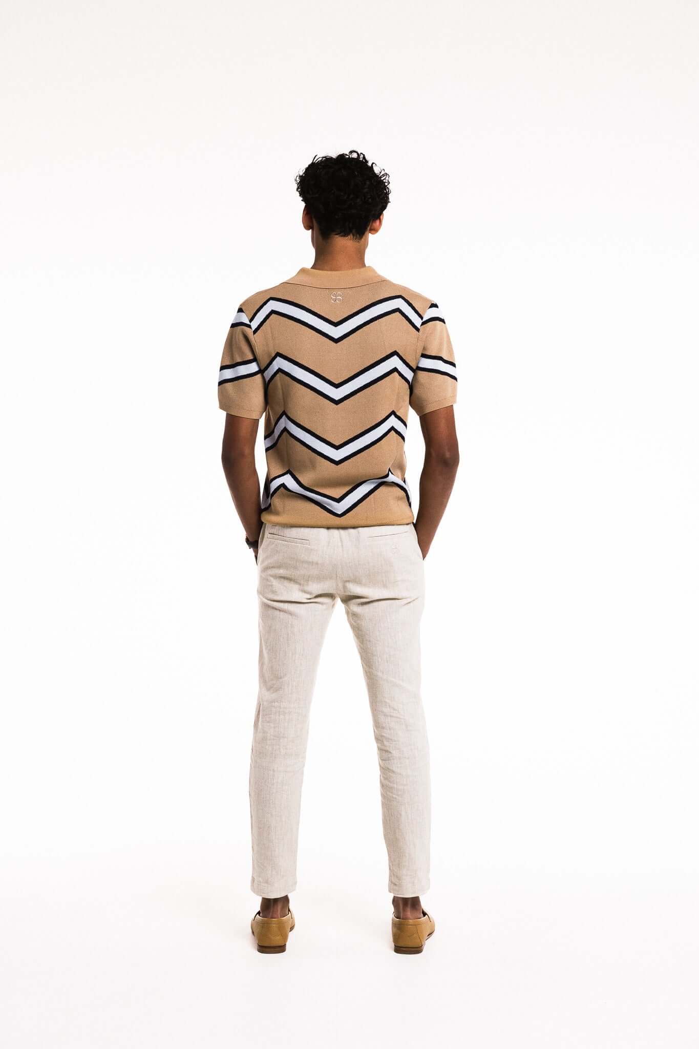 Model wearing Chevron Zigzag Polo in Caramel, showcasing bold zigzag stripes, regular fit, and elegant silhouette.