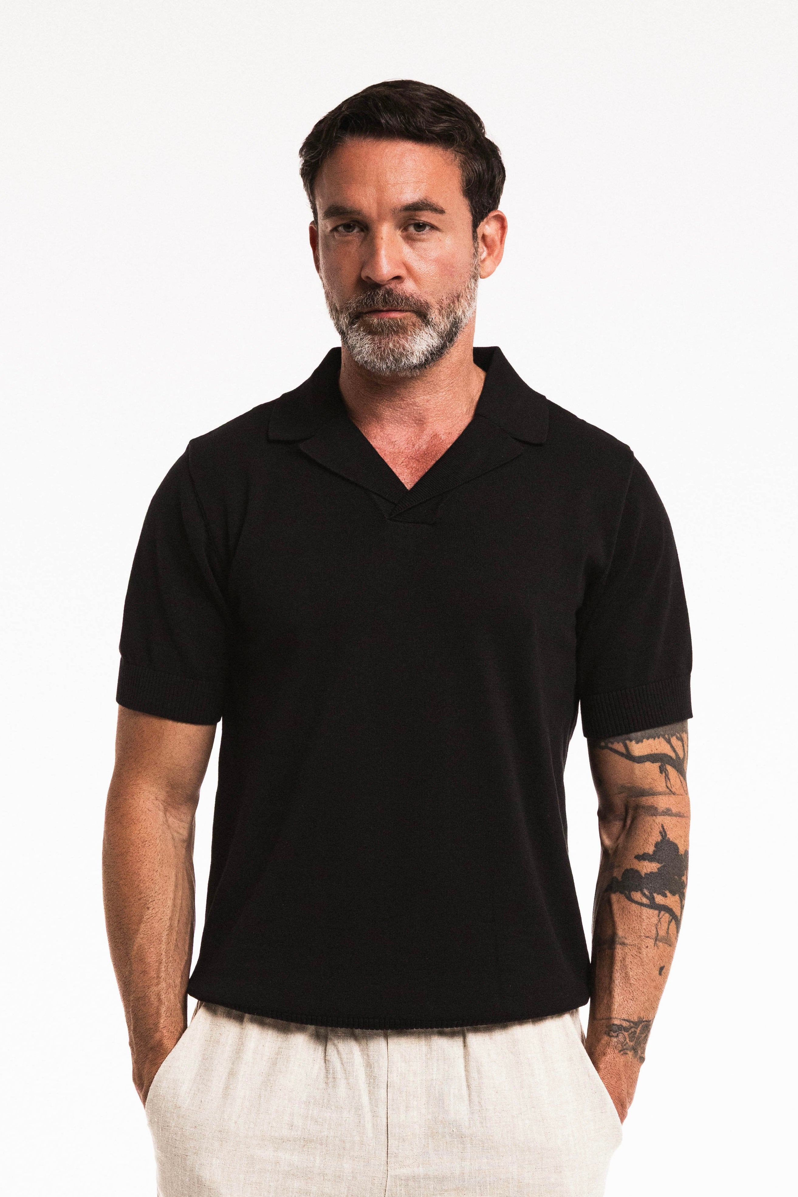 Classic Cotton Knit Polo in Obsidian worn by a man with tattoos, showcasing a refined and structured fit.