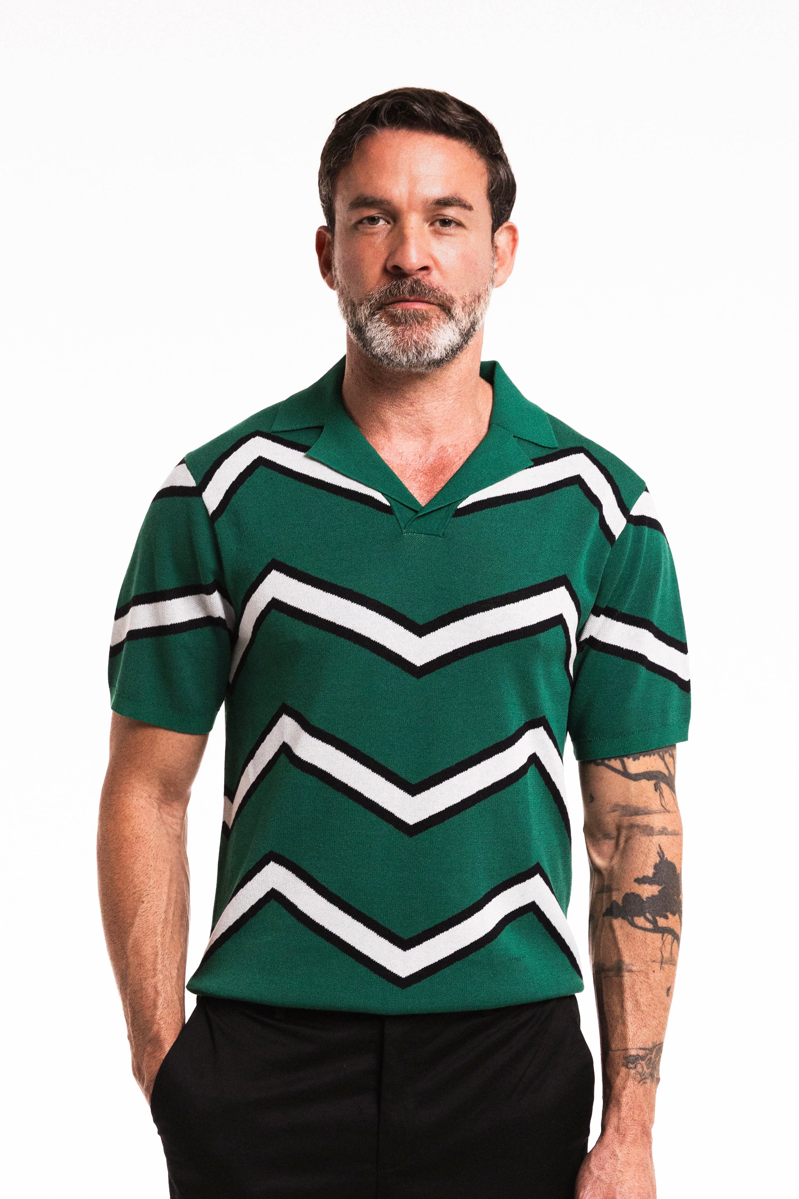 Man wearing a Chevron ZigZag Polo in Forest Green with bold zigzag stripes.