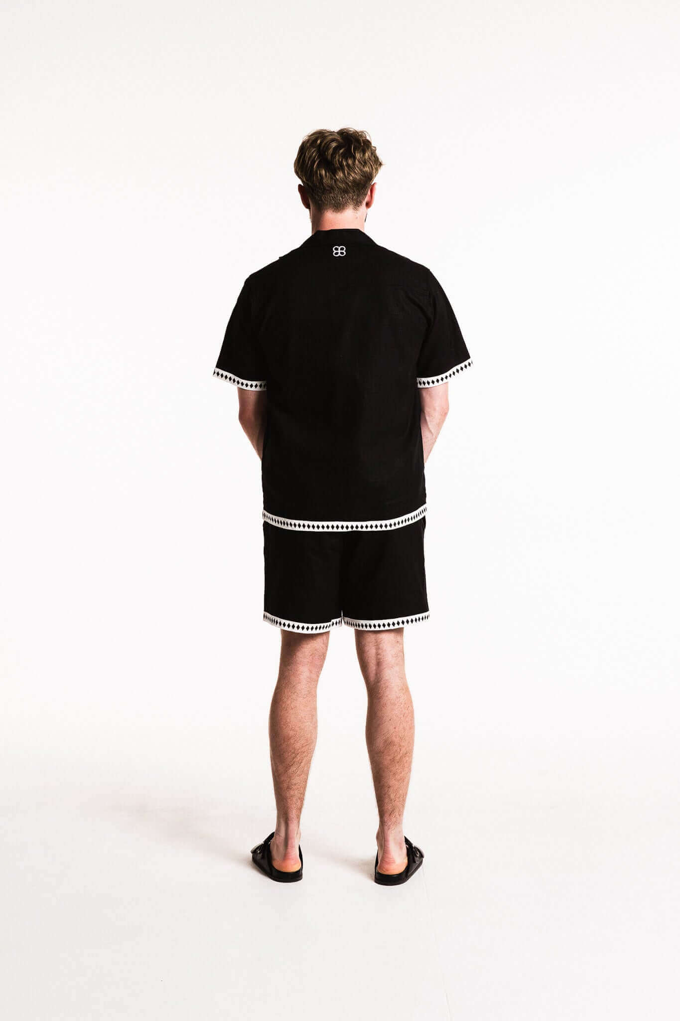 Diamond Trim Linen Shirt black with white contrast trim, back view on model wearing shorts for relaxed summer style.