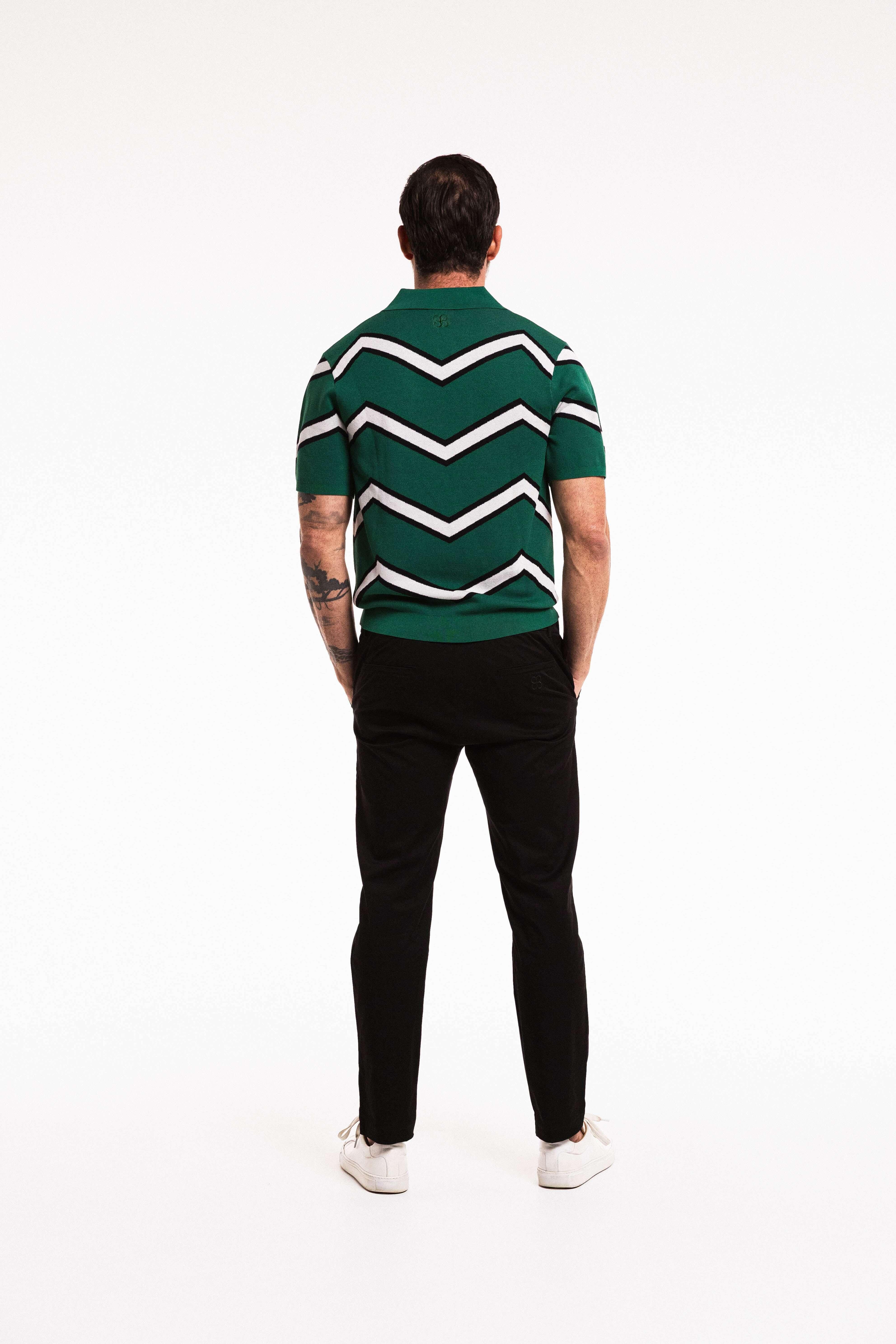 Model wearing Chevron Polo in Forest Green – back view standing