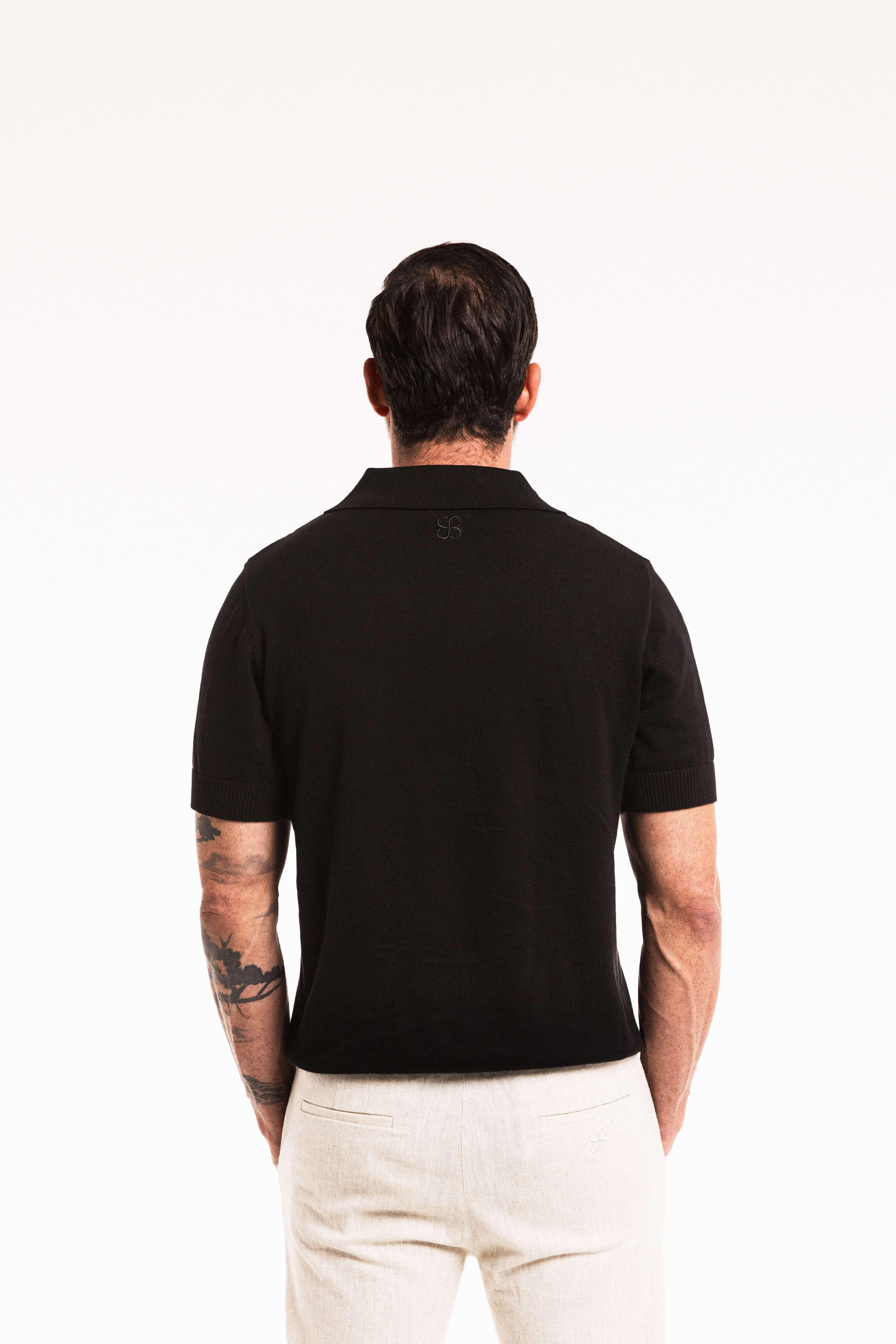 Close-up back view of model wearing Classic Polo in Obsidian – ribbed collar and knit detail