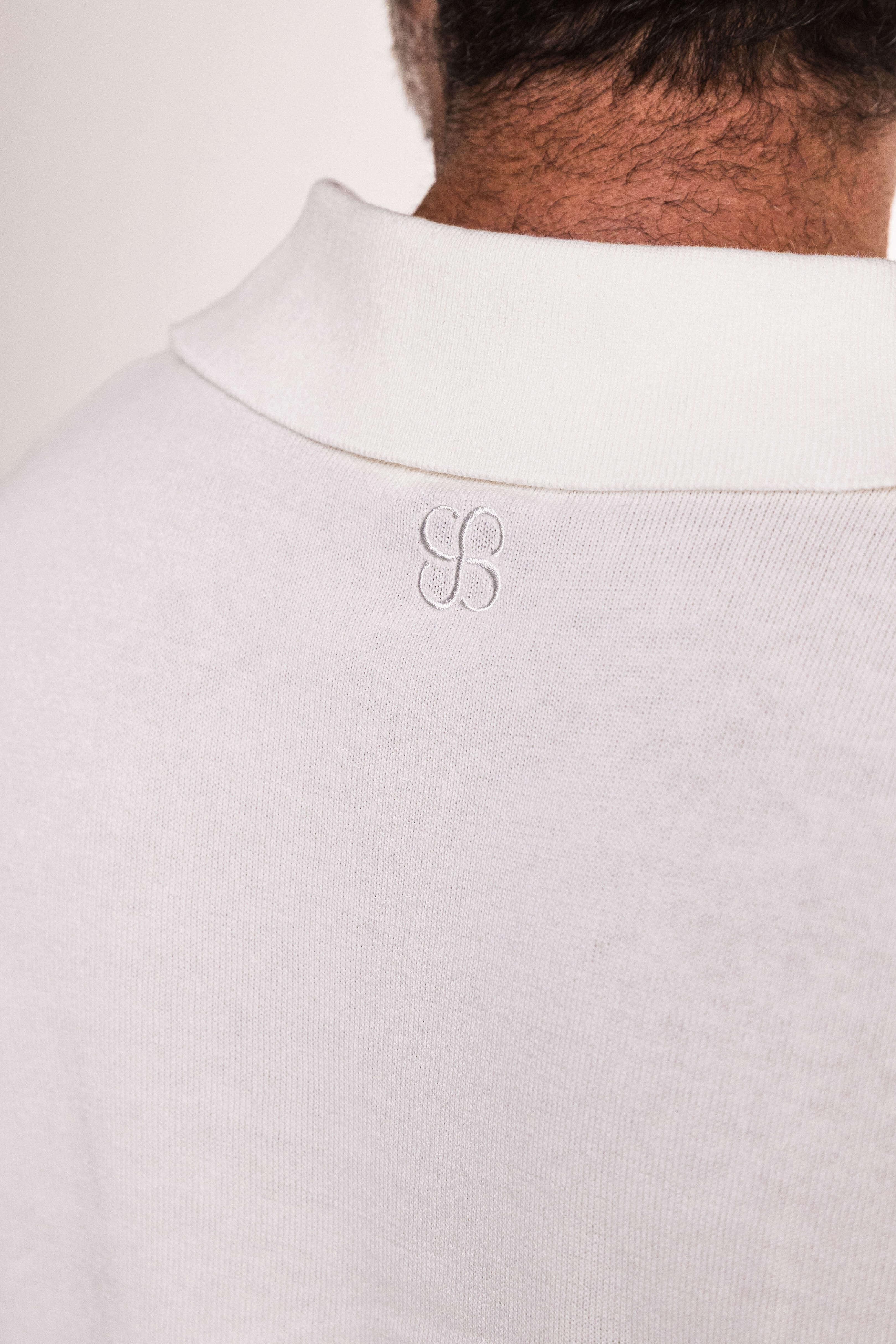 Close-up of fabric texture and stitching – ivory knit polo shirt
